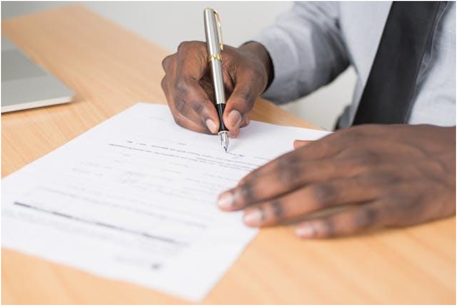 A pair of hands signing a contract